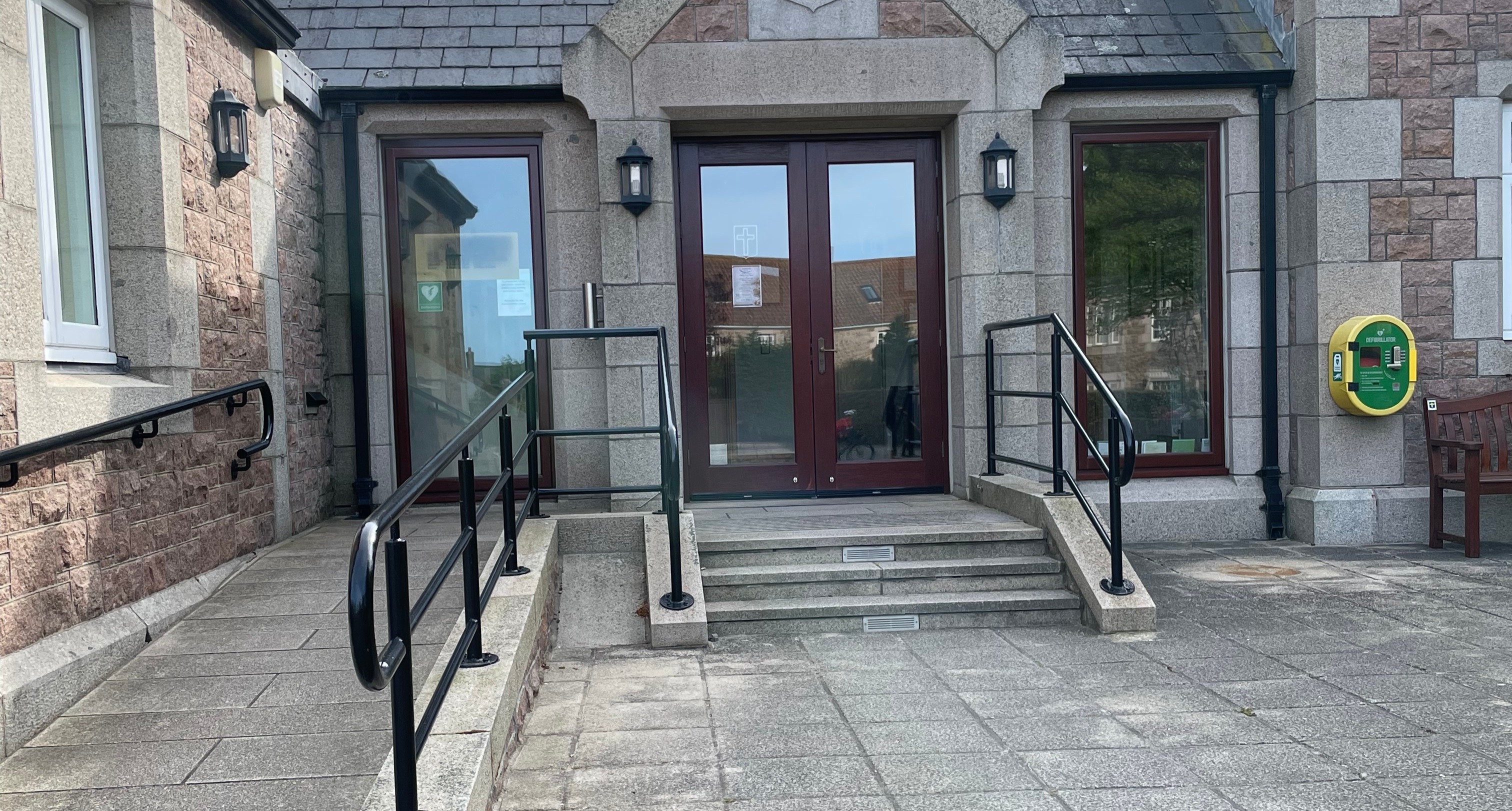 Side entrance to St Ouen Parish Hall with stairs and ramp access.