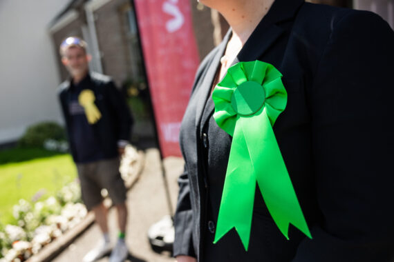 Two candidates outside a polling station welcoming voters