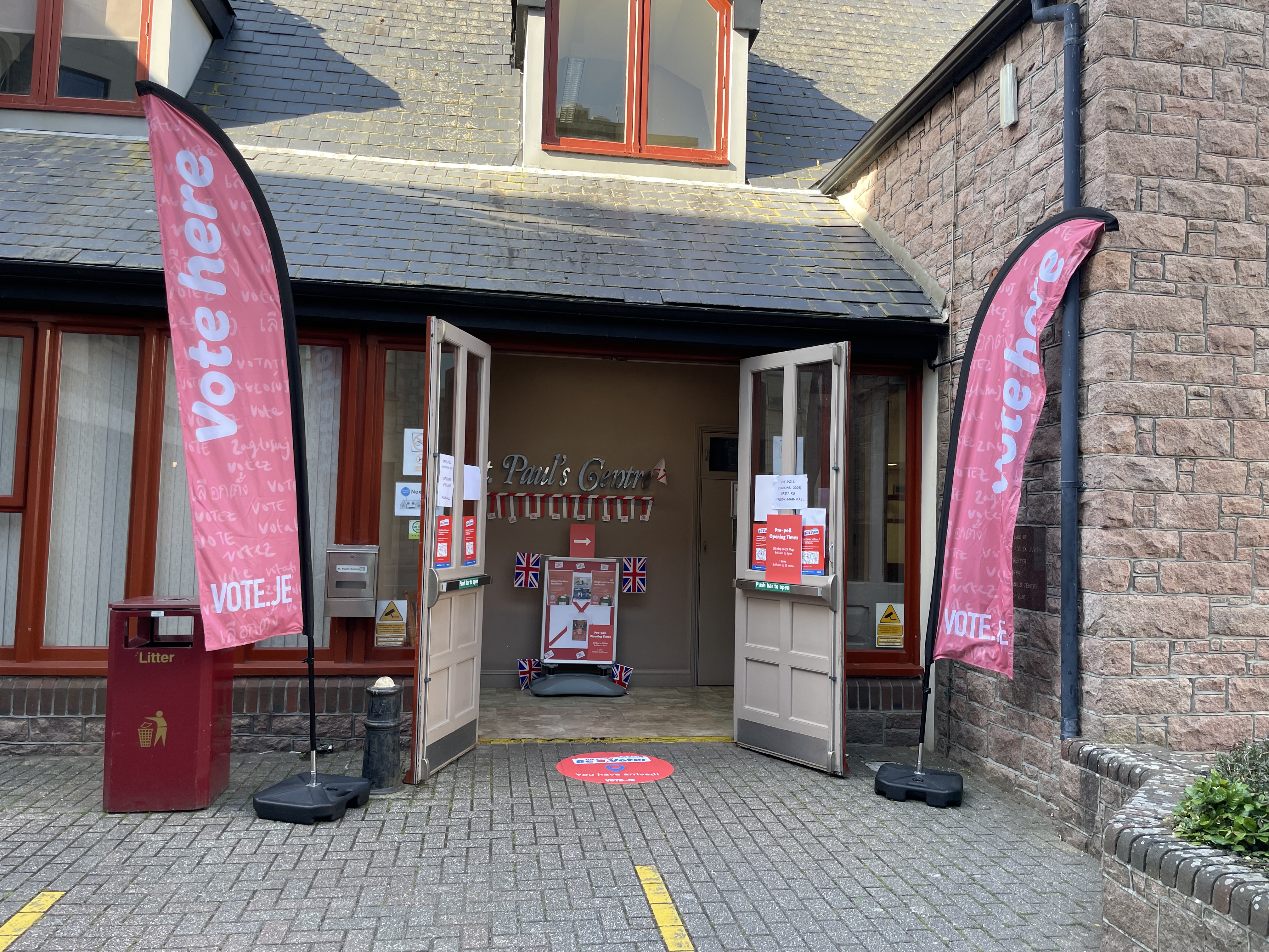 Close of main entrance to St. Paul's Centre with Vote.je flags either side of the entrance