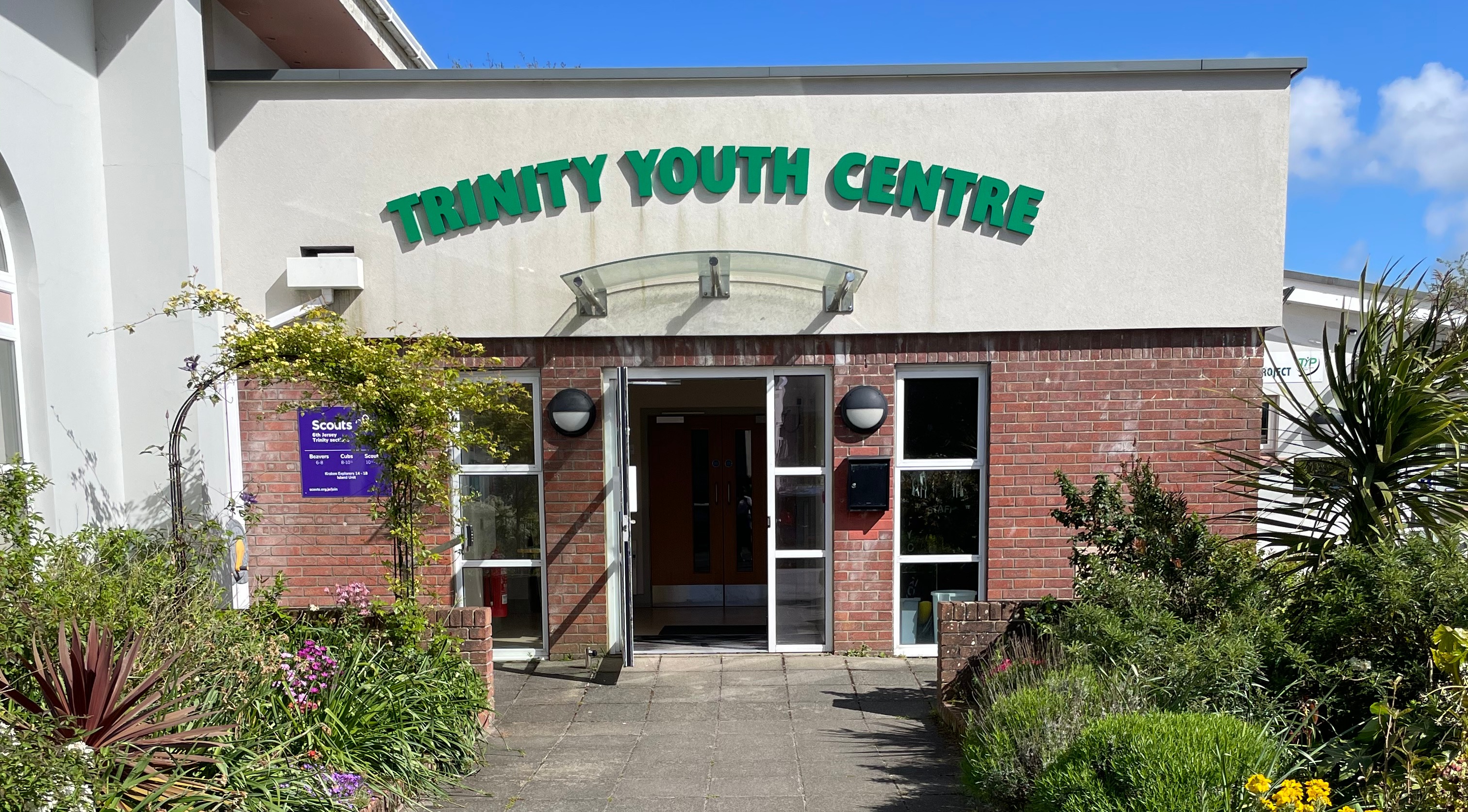 Close up of entrance to Trinity Youth Centre. Glass door open and window panels either side