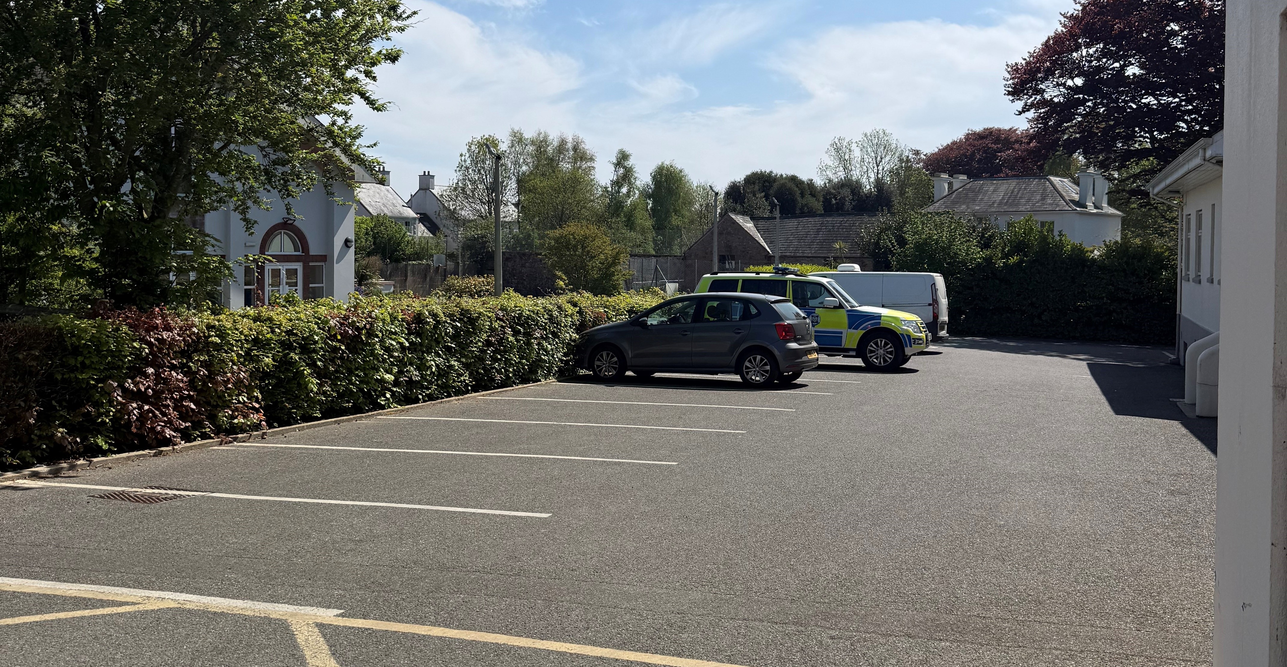 Outdoor parking area showing 5 empty spaces and 2 cars parked in other spaces